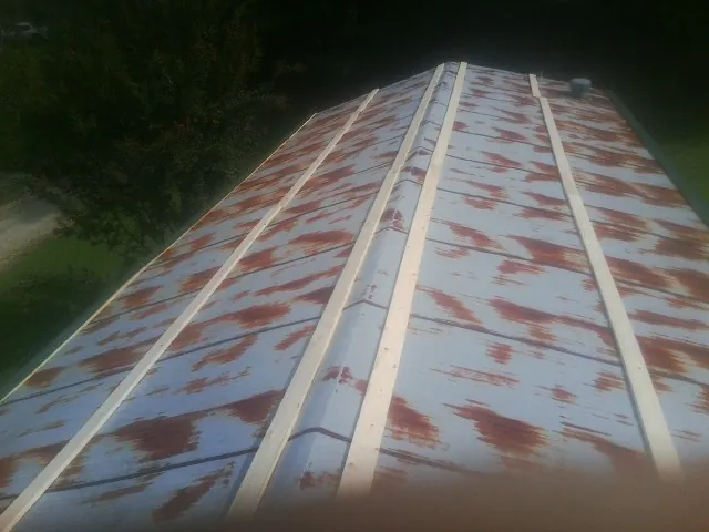 Rusted metal roof panels with new wood purlins before replacement — Storm Damage Roof Repair in Aledo by Roofing Brothers